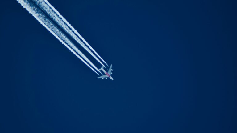 Avion de ligne en croisière laissant des traînées de condensation dans un ciel bleu