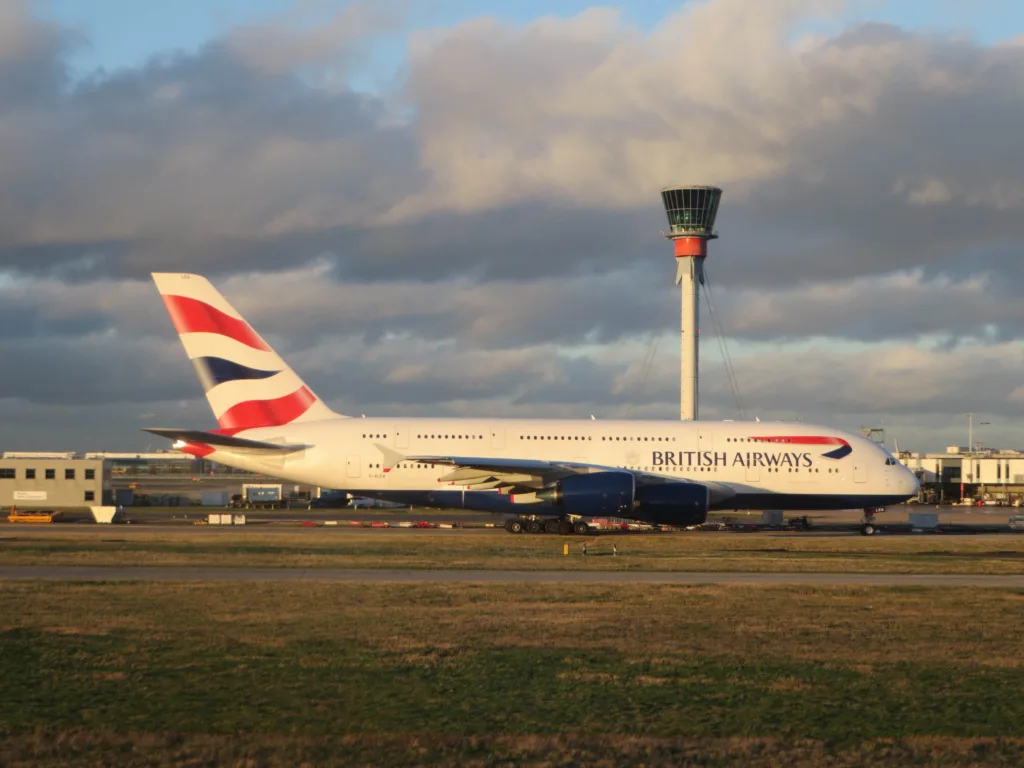 British Airways Airbus A380 G-XLEA at London Heathrow with the airport control tower behind it in evening light