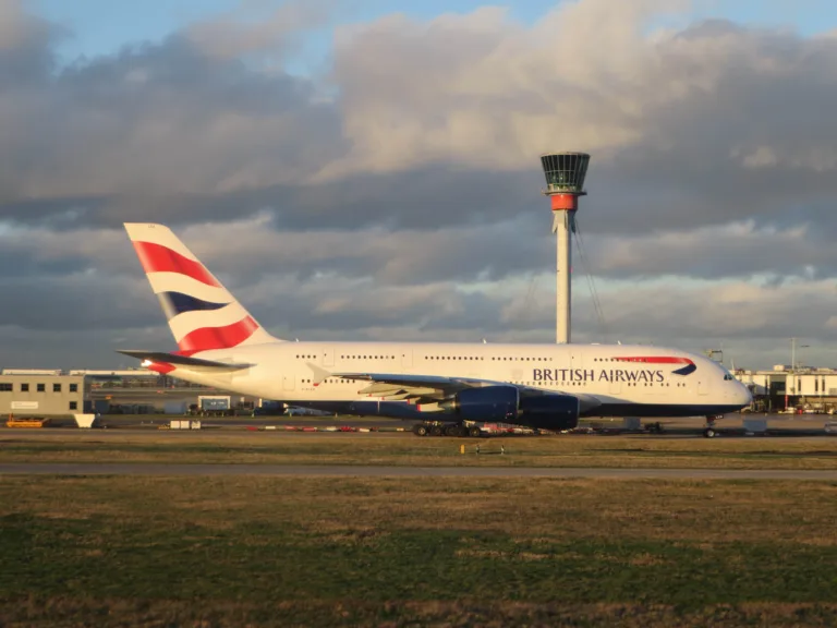 British Airways Airbus A380 G-XLEA at London Heathrow with the airport control tower behind it in evening light