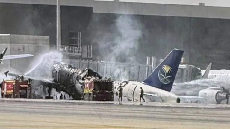 Épave calcinée d'un avion Saudia sur le tarmac de Riyad, entourée de véhicules de secours et de mousse anti-incendie.