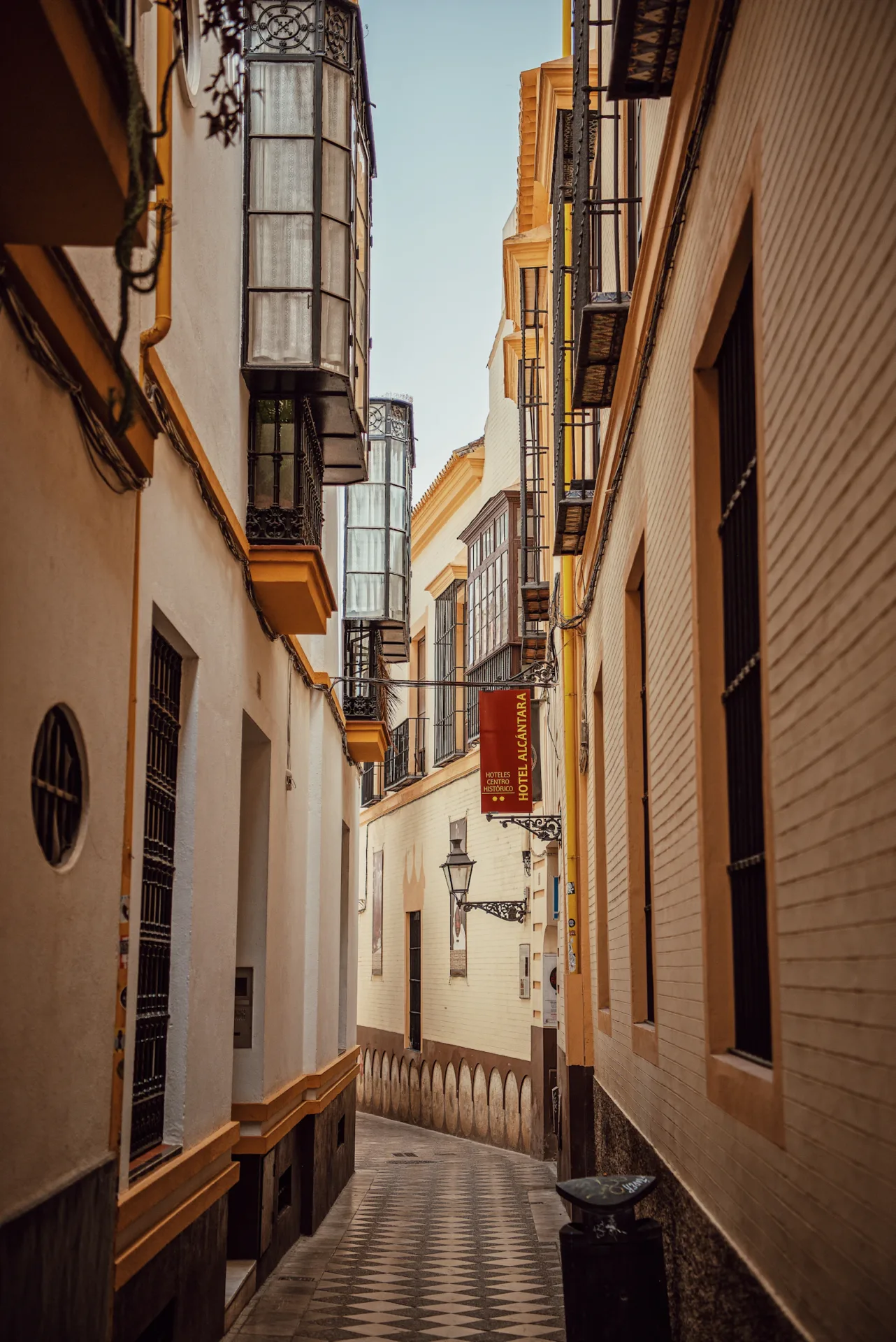 Ruelle étroite bordée de façades dans le quartier Santa Cruz à Séville